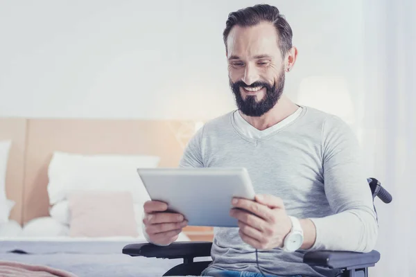 Joven trabajador independiente con discapacidad sosteniendo una tableta y sonriendo — Foto de Stock