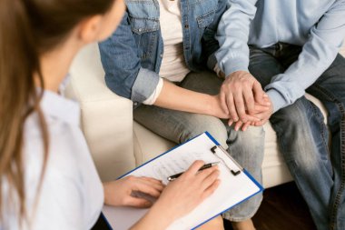 Çift terapisi. Profesyonel akıllı kadın psikolog notlarını tutan ve onları psikolojik bir oturumla yaparken evli bir çift söz