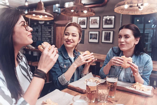 Heureuses femmes gaies profitant de leurs hamburgers — Photo