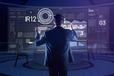 Geniş bir odada duran ve sanal gerçeklik gözlükle genç adam