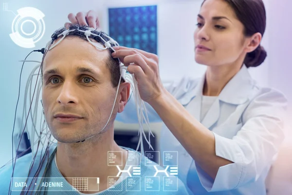 Vorsichtiger Arzt verbindet Drähte am Kopf ihrer ruhigen Patientin — Stockfoto