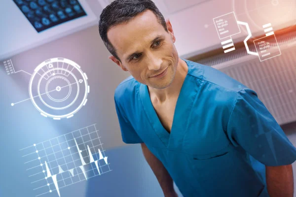 Bello medico sorridente e indossa uniforme blu al lavoro — Foto Stock