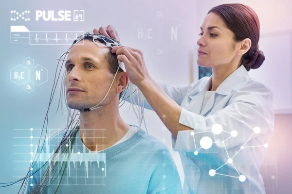 Attenta infermiera toccare fili mentre li controlla prima di fare EEG — Foto Stock