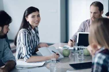 Onun meslektaşları ile oturma pozitif gülümseyen kadın