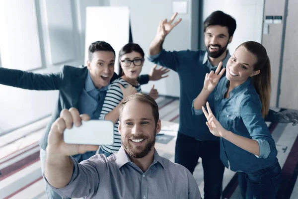 Jóvenes colegas positivos haciendo selfies —  Fotos de Stock