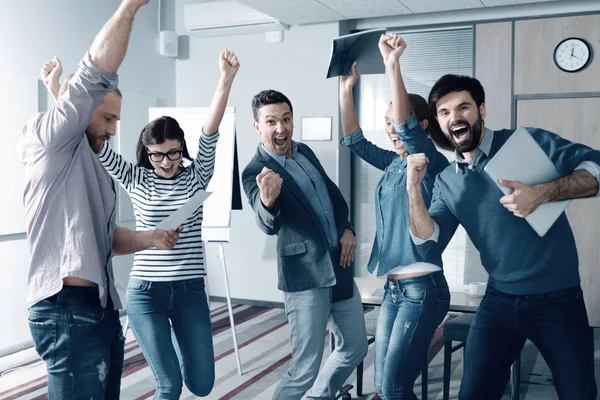 Overjoyed young colleagues celebrating a successful project — Stock Photo, Image