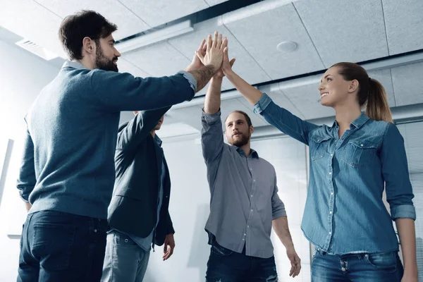 Grupo positivo de pessoas dando mais cinco uns aos outros — Fotografia de Stock