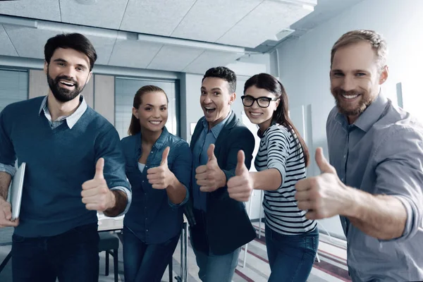 Cheerful young colleagues thumbing up — Stock Photo, Image