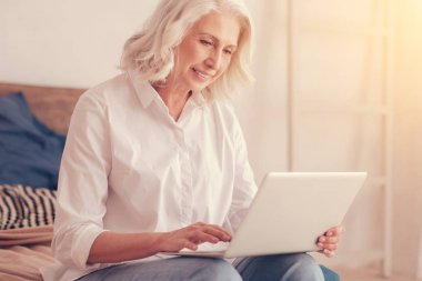 Güzel yaşlı Bayan laptop evde çalışma