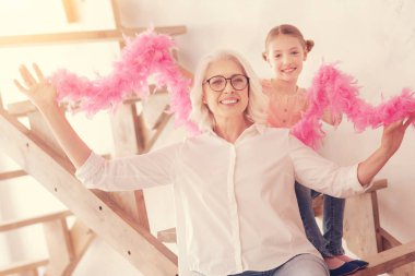 Heyecanlı büyükanne ve Genç Bayan tüy boa ile poz