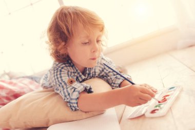 Küçük çocuk onun yeni resim için renk seçimi konsantre