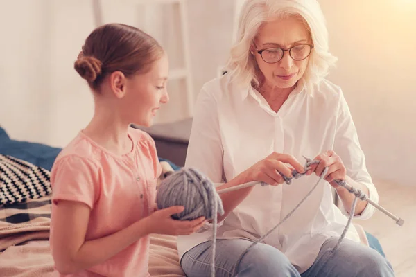 Amantísima abuela enseñando a la niña a tejer —  Fotos de Stock