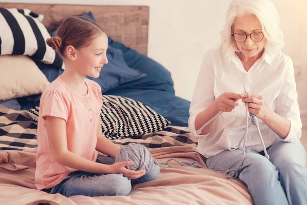 Glad tjej tittar mormor stickning varm halsduk — Stockfoto