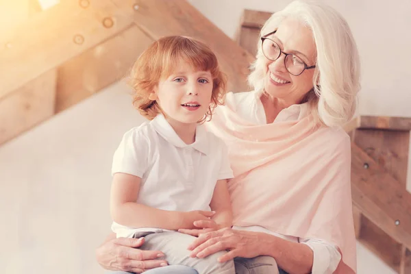 Schattige jongen zittend op schoot van lachende oma — Stockfoto