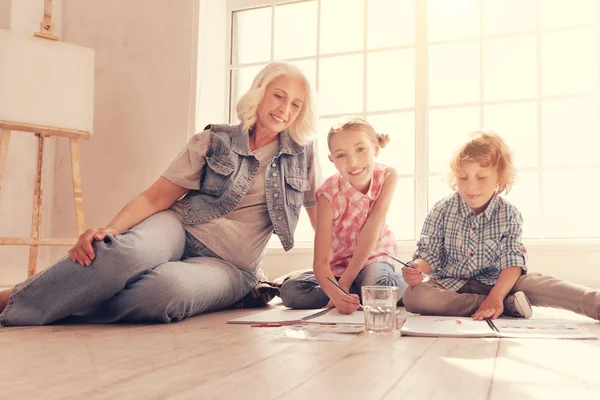 Talentierte Kinder malen mit Oma auf dem Boden — Stockfoto