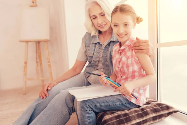 Lachende preteen meisje poseren voor de camera tijdens het tekenen — Stockfoto