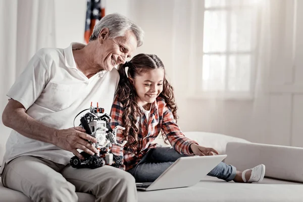 Smiling happy grandpa sharing his memories with granddaughter