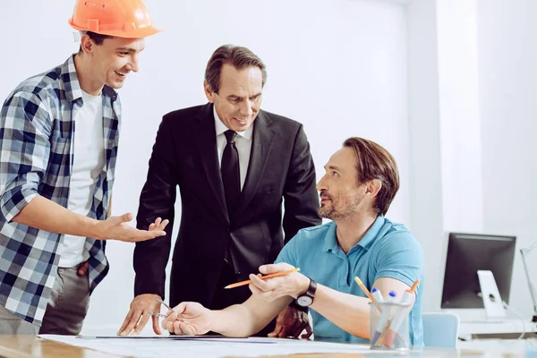 Colegas amigáveis discutindo uma história emocionante no local de trabalho — Fotografia de Stock