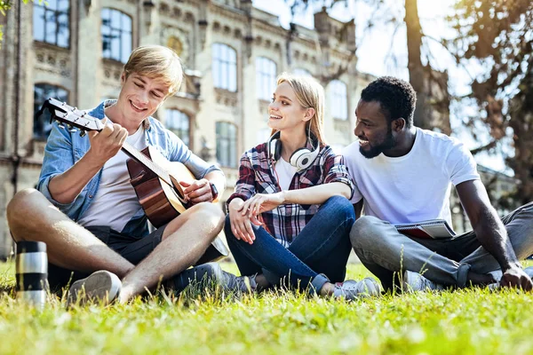 Migliori amici che suonano la chitarra mentre trascorrono del tempo all'aperto — Foto Stock