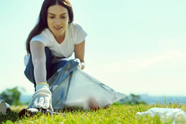 Konsantre kadın cam şişe toplama