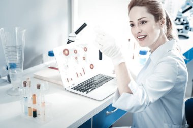 Belgili tanımlık laptop önünde oturan güzel akıllı bilim adamı