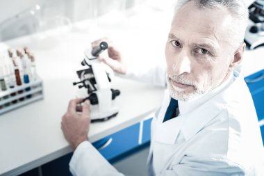 Mikroskop holding ciddi yakışıklı adam