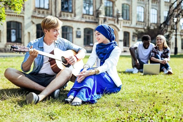 Hezký chlap, hraje na kytaru pro krásnou dívku — Stock fotografie