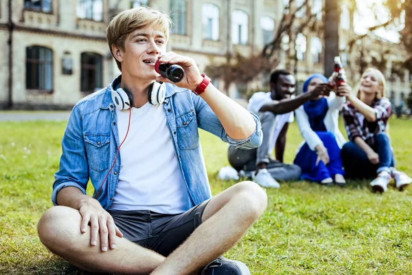 Bello biondo ragazzo bere acqua scintillante all'aperto — Foto Stock