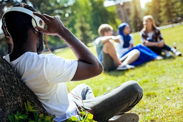 Relaxed young man listening to music outdoors — Stock Photo, Image