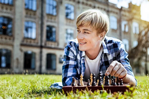 Cara pensativo sorrindo enquanto joga xadrez — Fotografia de Stock