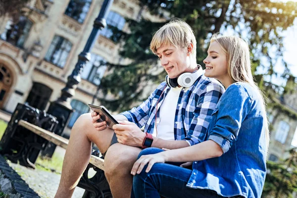 Jonge mensen glimlachen terwijl het touchpad buitenshuis kijken — Stockfoto