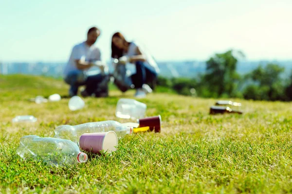 Pareja amable limpiando el parque de basura —  Fotos de Stock