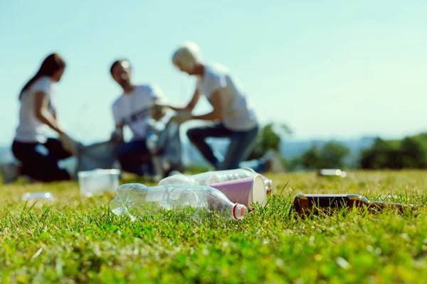 Fotografía enfocada en botellas de plástico que estando en la hierba —  Fotos de Stock