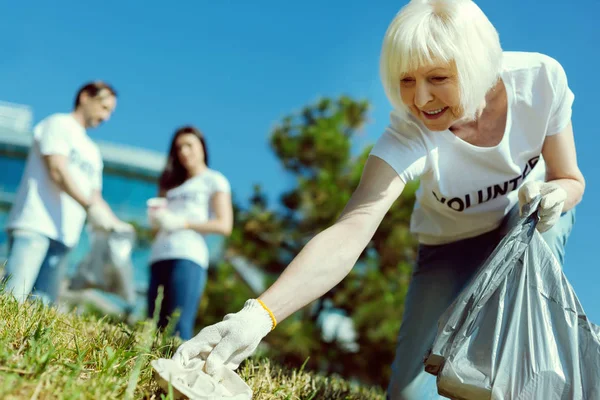 Positive delighted female collecting plastic — стоковое фото