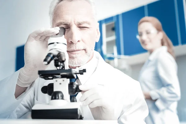 Slimme knappe bioloog op zoek naar de Microscoop — Stockfoto