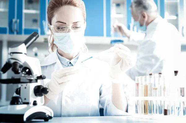 Nice female scientist sitting in front of the microscope — Stock Photo, Image