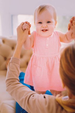 Ellerini tutan bir tür anne gülümseyen duygusal yürümeye başlayan çocuk