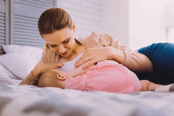 Giovane madre cercando calma durante l'allattamento al seno il suo bambino — Foto Stock