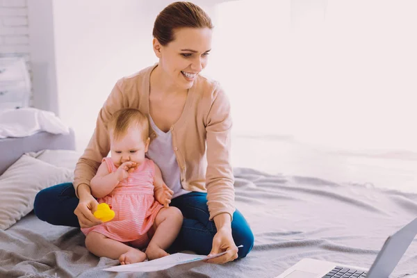 Femme d'affaires enthousiaste avoir une journée productive tout en restant avec un bébé — Photo