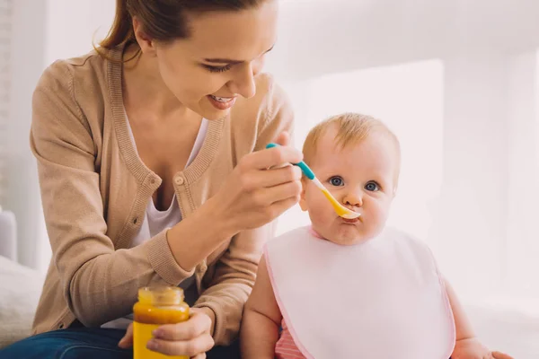 Carino bambino cercando calma mentre una babysitter che la alimenta — Foto Stock