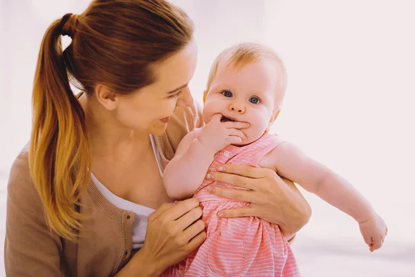 Genitore allegro sorridente mentre guarda il suo bambino calmo e premuroso — Foto Stock