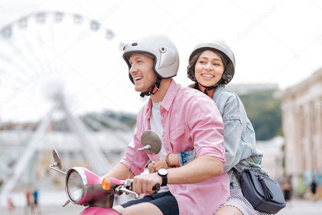 Happy cheerful man taking girl on motorbike