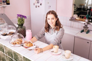 Gülümseyen öğrenci okuduktan sonra kahve sunucu olarak çalışıyor