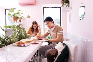 Kruvasan ve kahve fırında sahip iki meşgul lisans öğrencileri