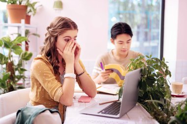 Güzel genç öğrenci sınava hazırlanıyor gerçekten uykulu hissediyorum