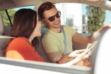 Koyu renk saçlı gülen kadın kocası komik bir mesaj gösterilen