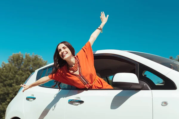Usmívající se krásná žena pocit svobody při cestování v autě — Stock fotografie
