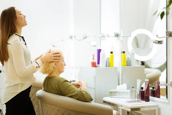 Mulher habilidosa inteligente segurando sua cabeça clientes — Fotografia de Stock