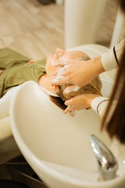 Schöne geschickte Friseurin Anwendung Shampoo — Stockfoto