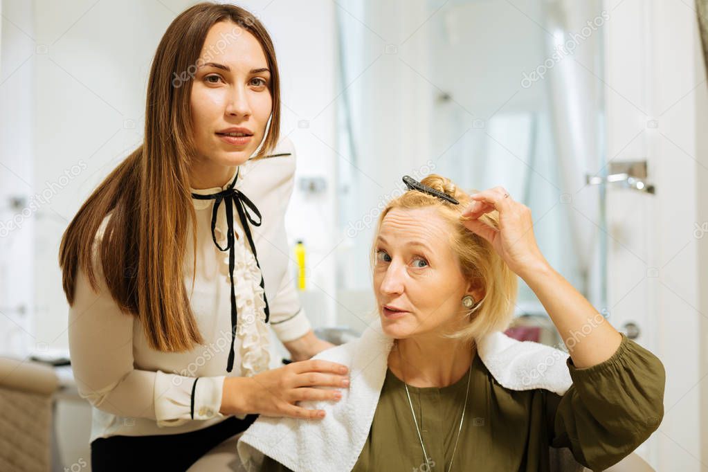 Smart skilled hairdresser listening to her client